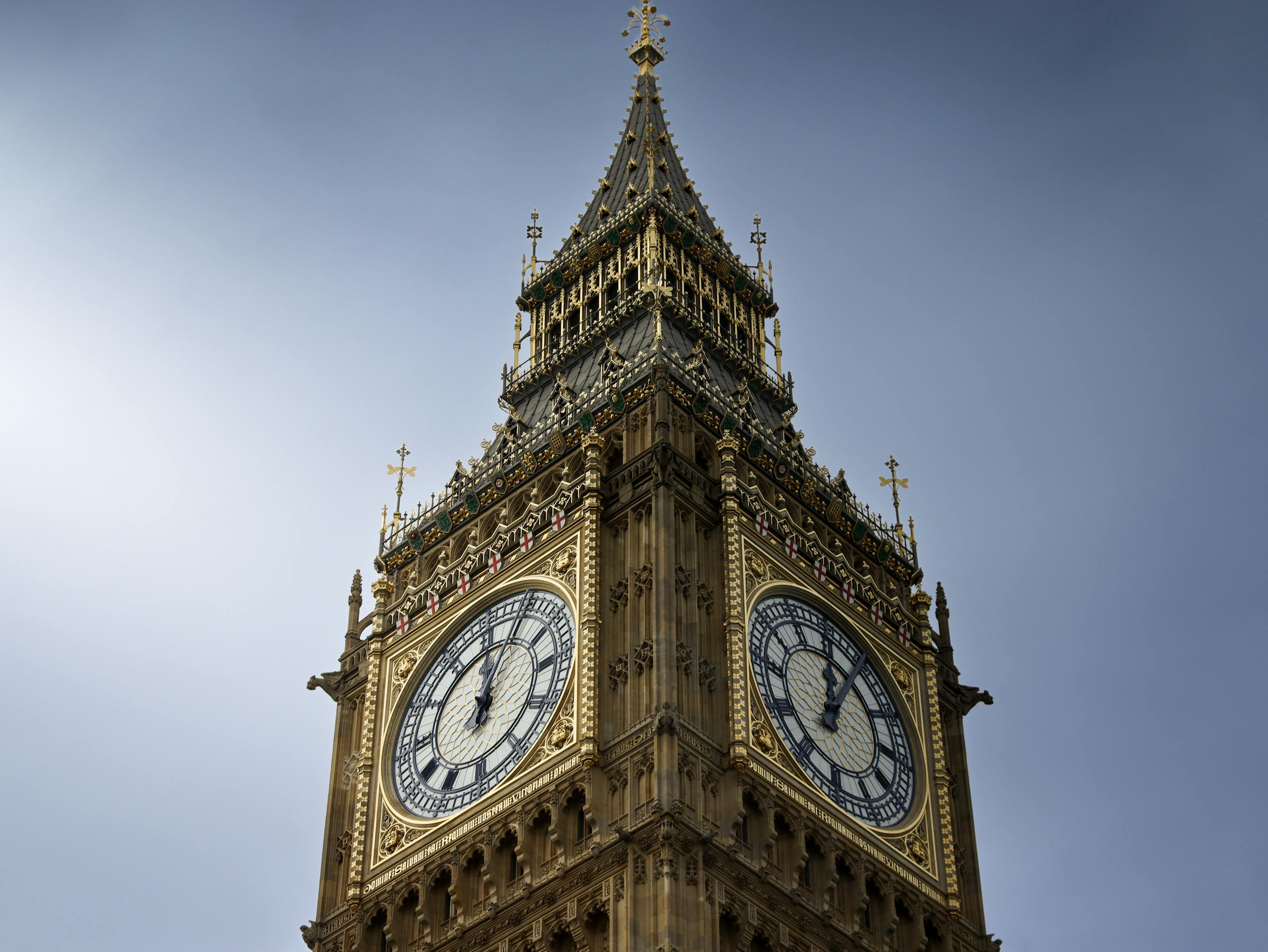 A close-up view of London's famous Big Ben clock tower under a clear blue sky.