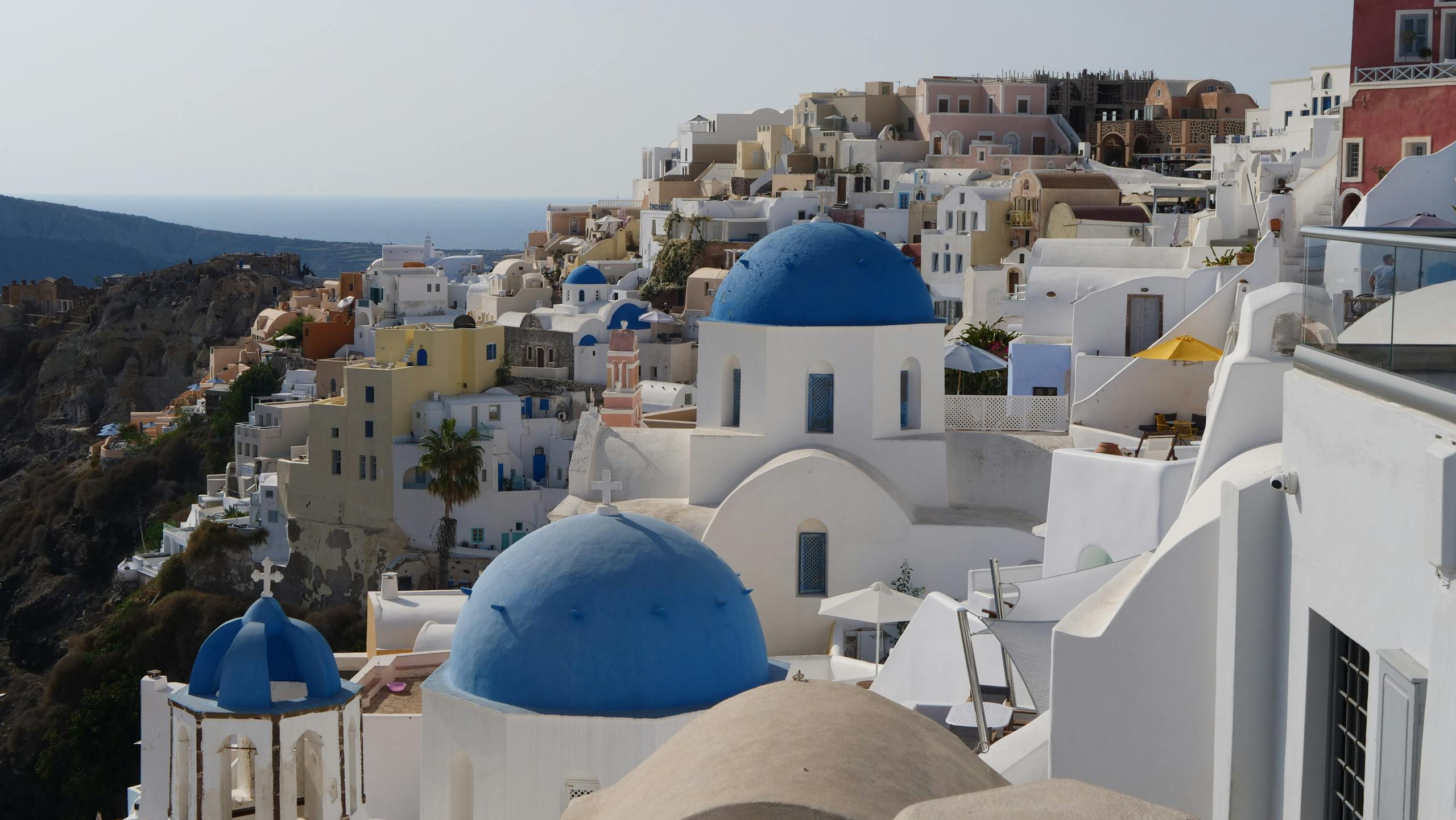 A picturesque view of Oia, Greece showcasing Santorini's iconic blue-domed churches and whitewashed buildings.