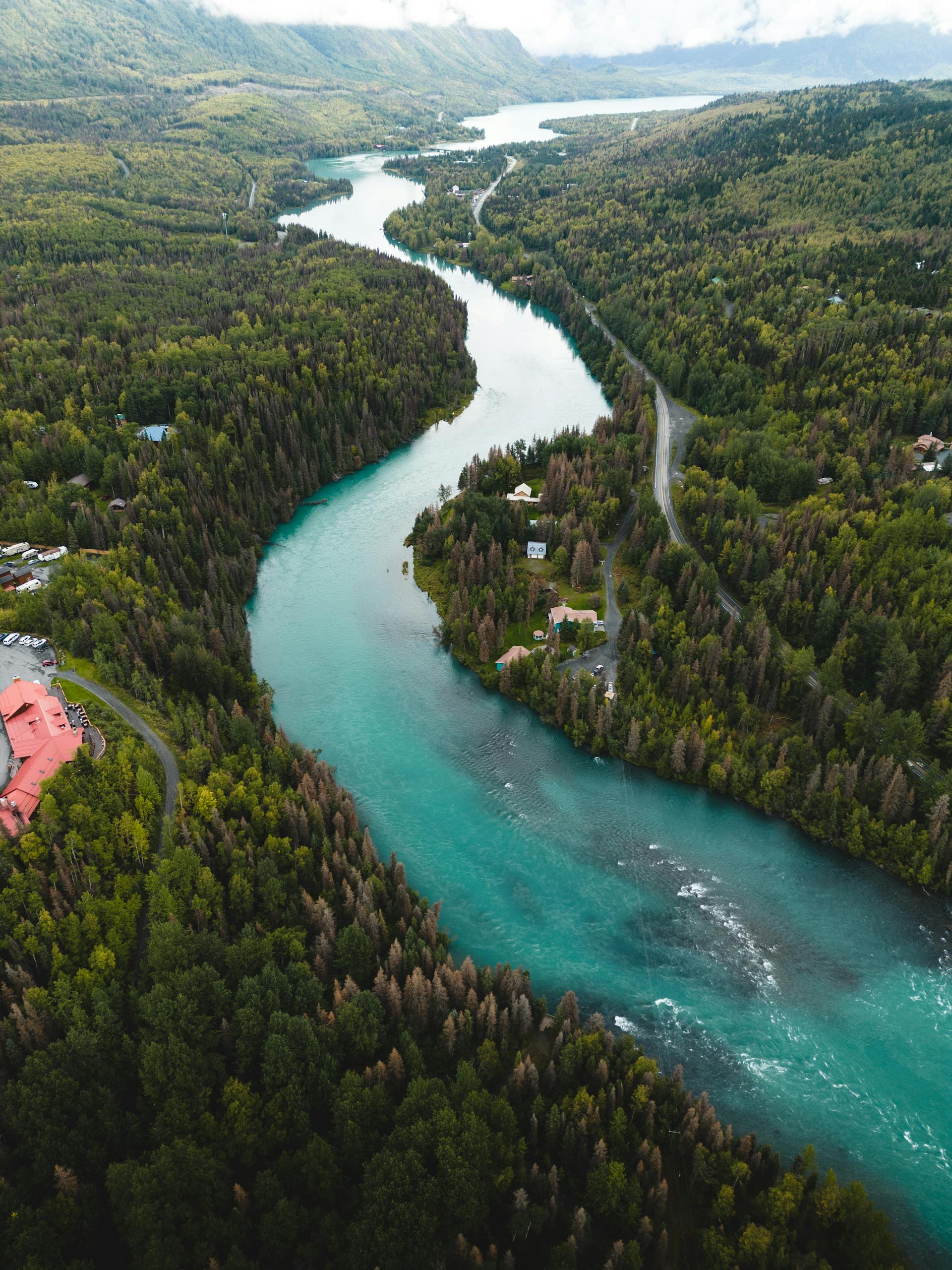 A stunning aerial view of the Kenai River winding through lush forests in Cooper Landing, Alaska.