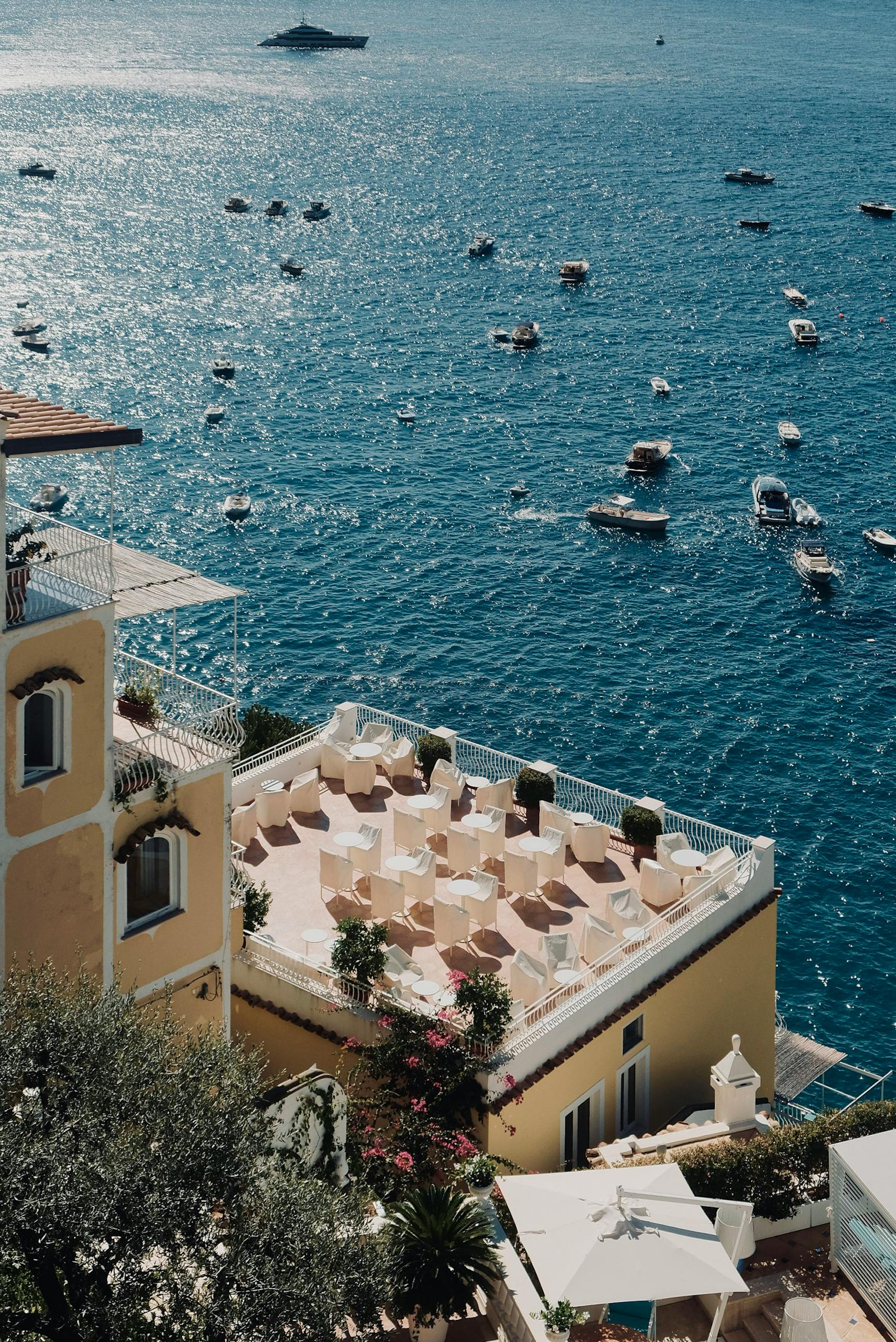 Aerial view of the Mediterranean coast in Campania, Italy with luxury yachts and azure waters.