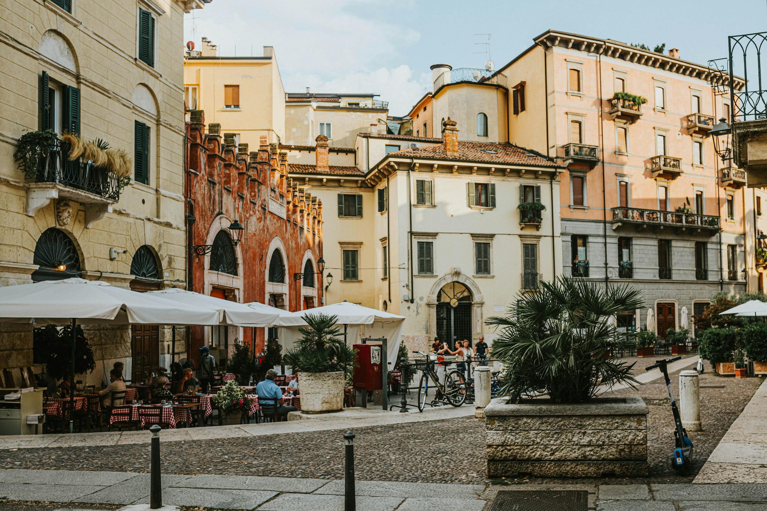 Explore the lively atmosphere of a Verona square filled with sidewalk cafes and historic architecture.