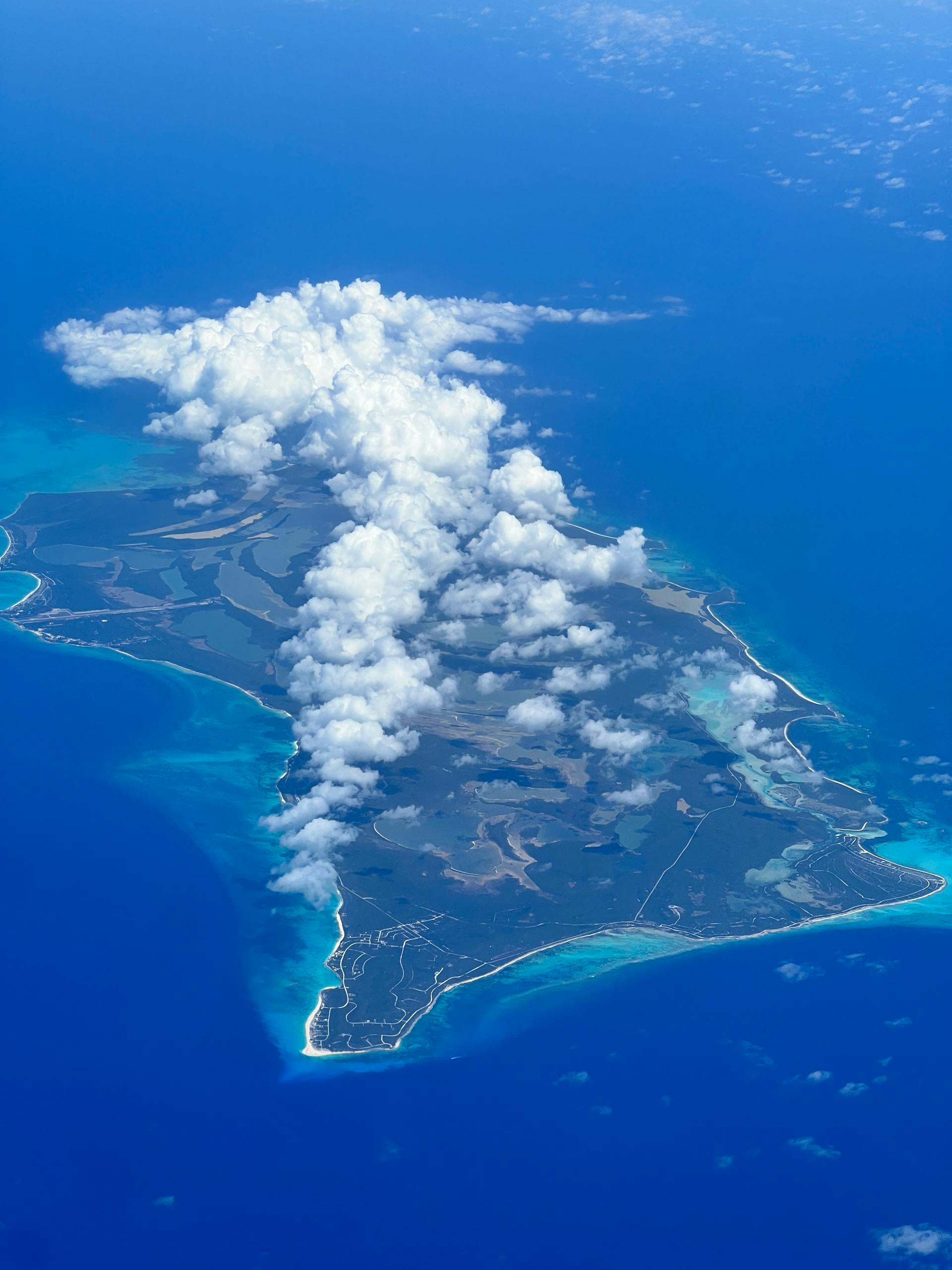 Stunning aerial view of a lush island surrounded by azure waters in the Bahamas.