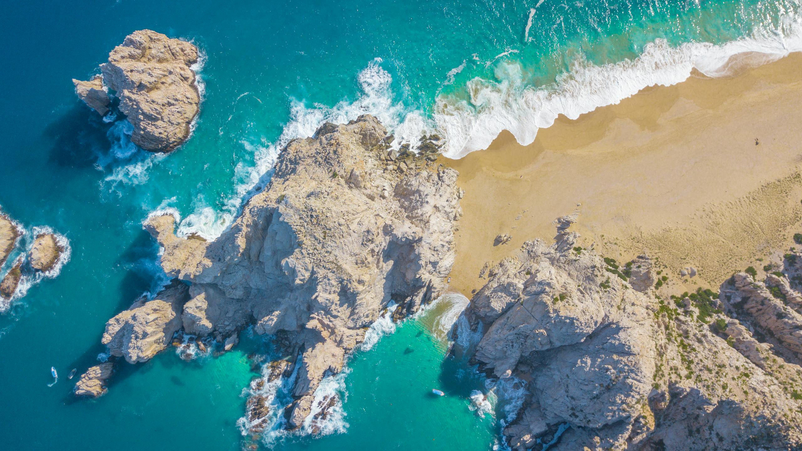A breathtaking aerial view of Cabo San Lucas' iconic beach showcasing rocky shores and turquoise waters.