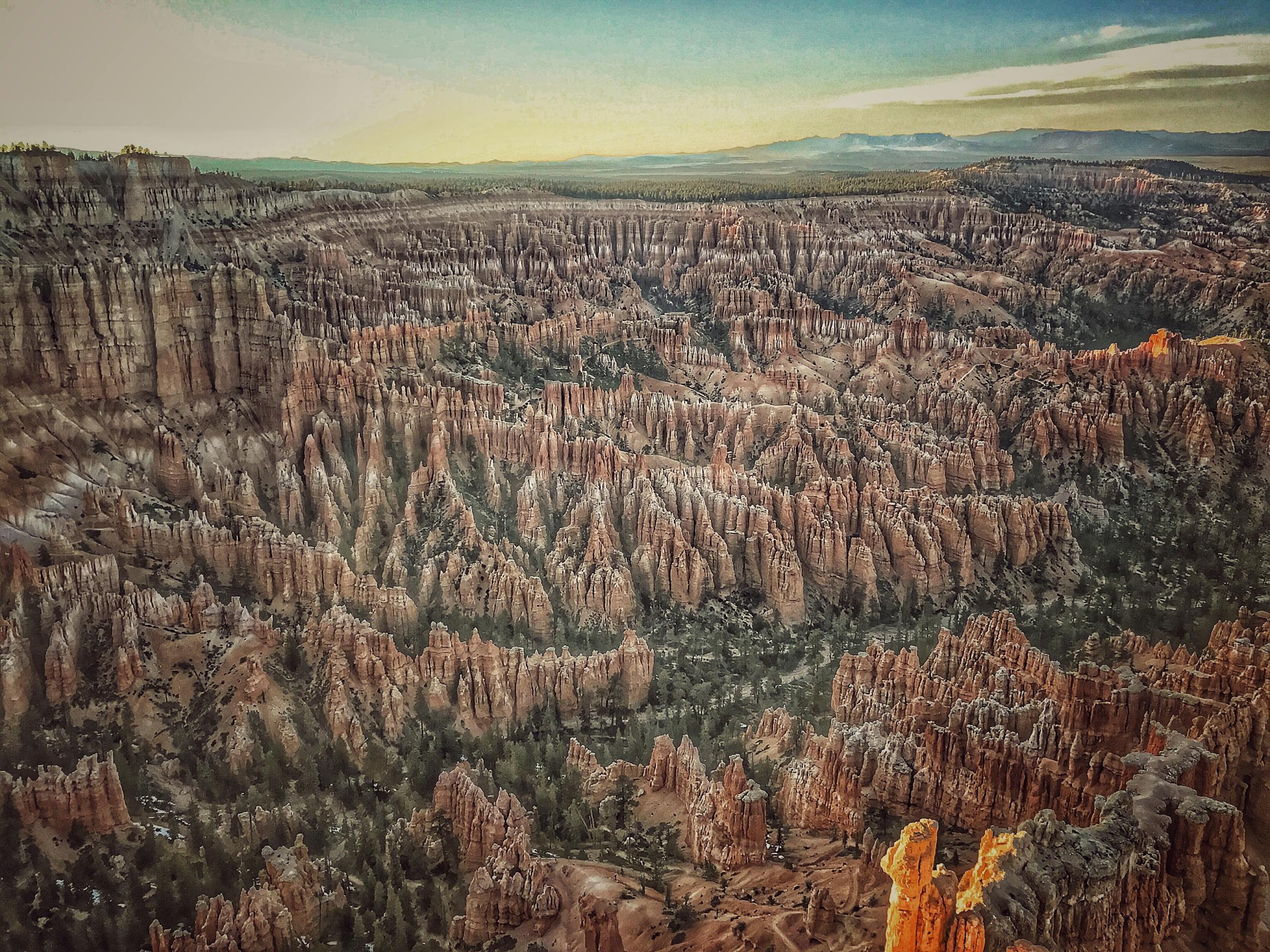 A stunning aerial view of Bryce Canyon's iconic hoodoos under a clear sky at dawn.