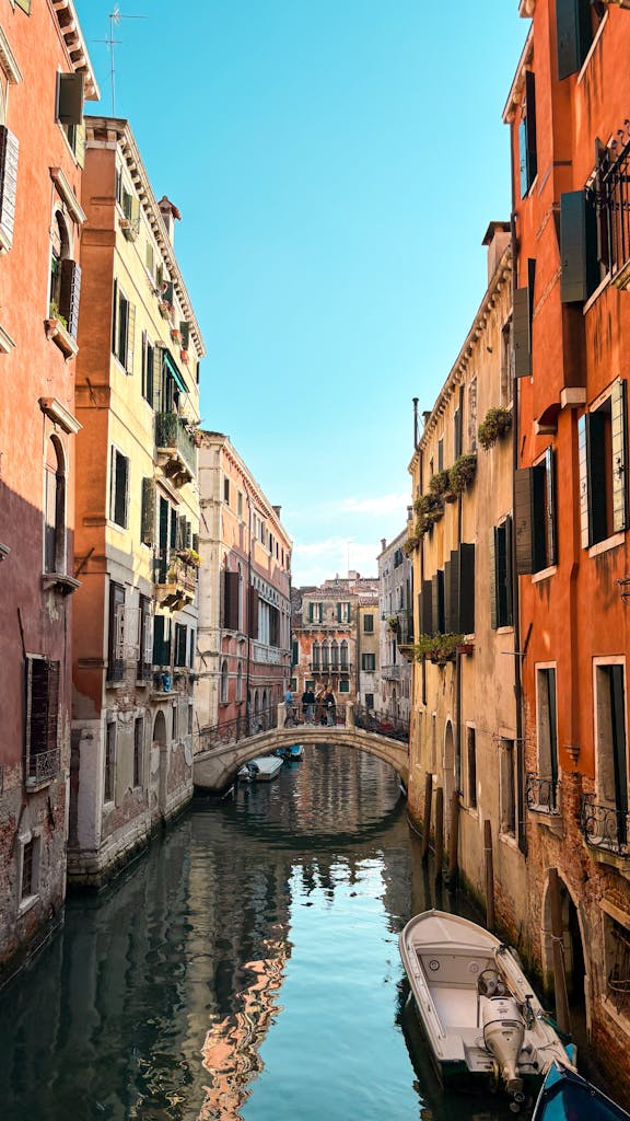 Charming Venice canal scene with colorful historic architecture and reflections under a clear sky.