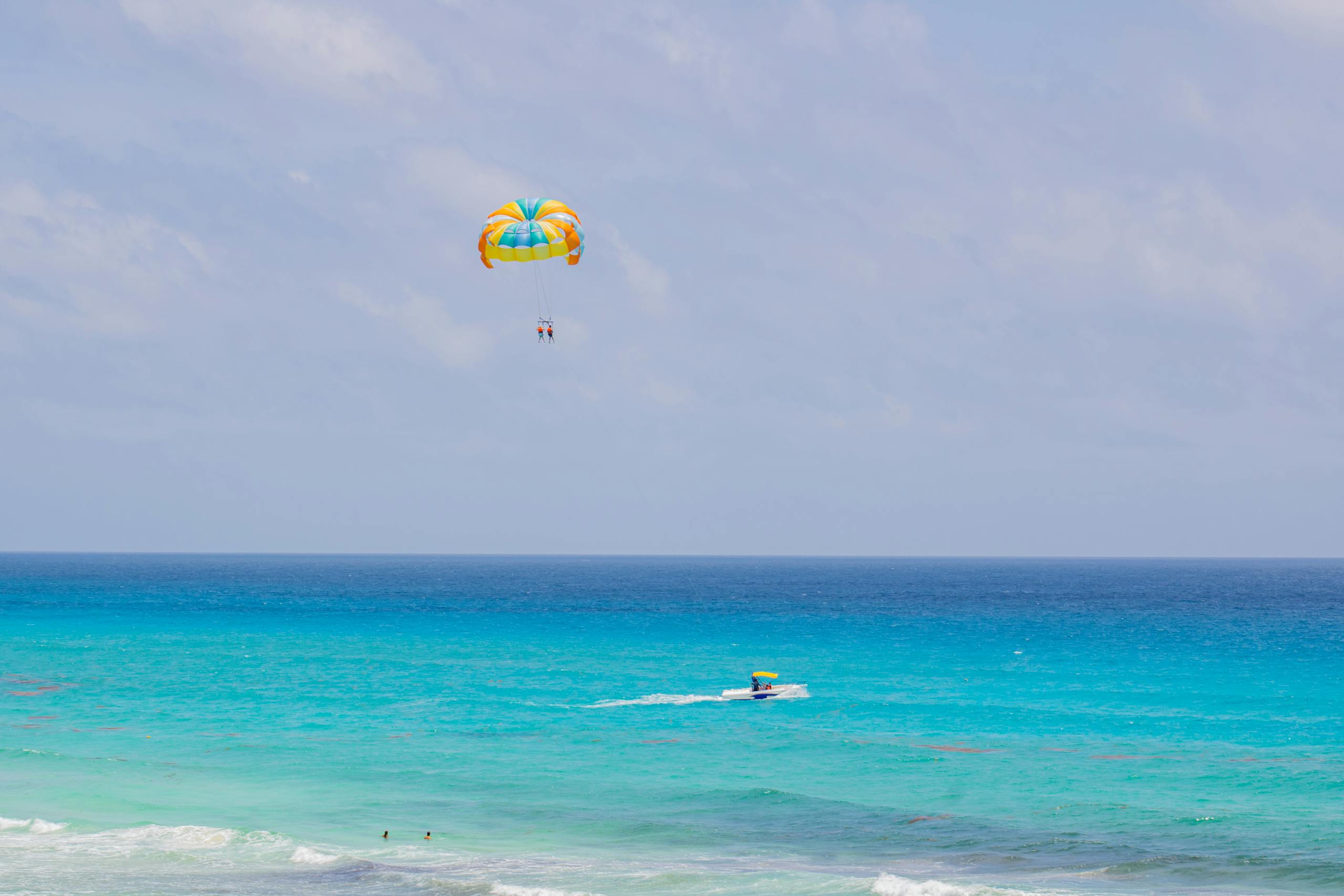 Experience thrilling parasailing above the turquoise sea in Cancún, México. Perfect vacation escape.