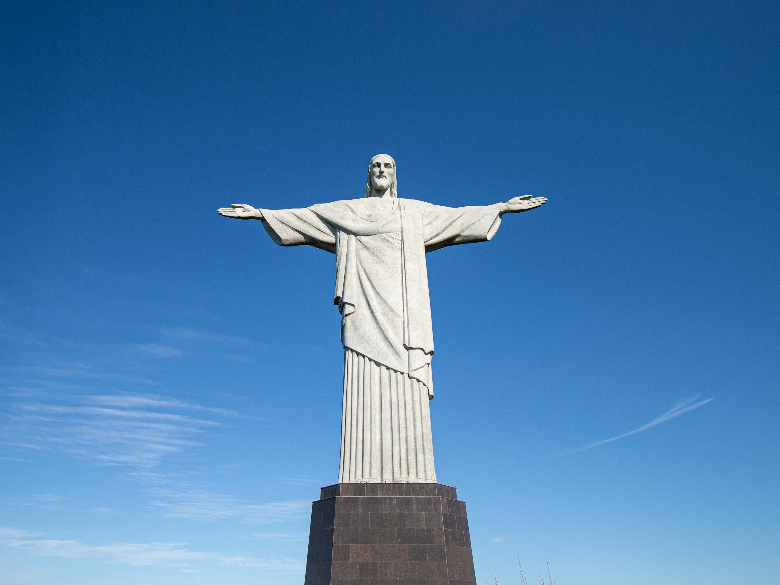 Iconic view of Christ the Redeemer statue against a clear blue sky in Rio de Janeiro, Brazil.