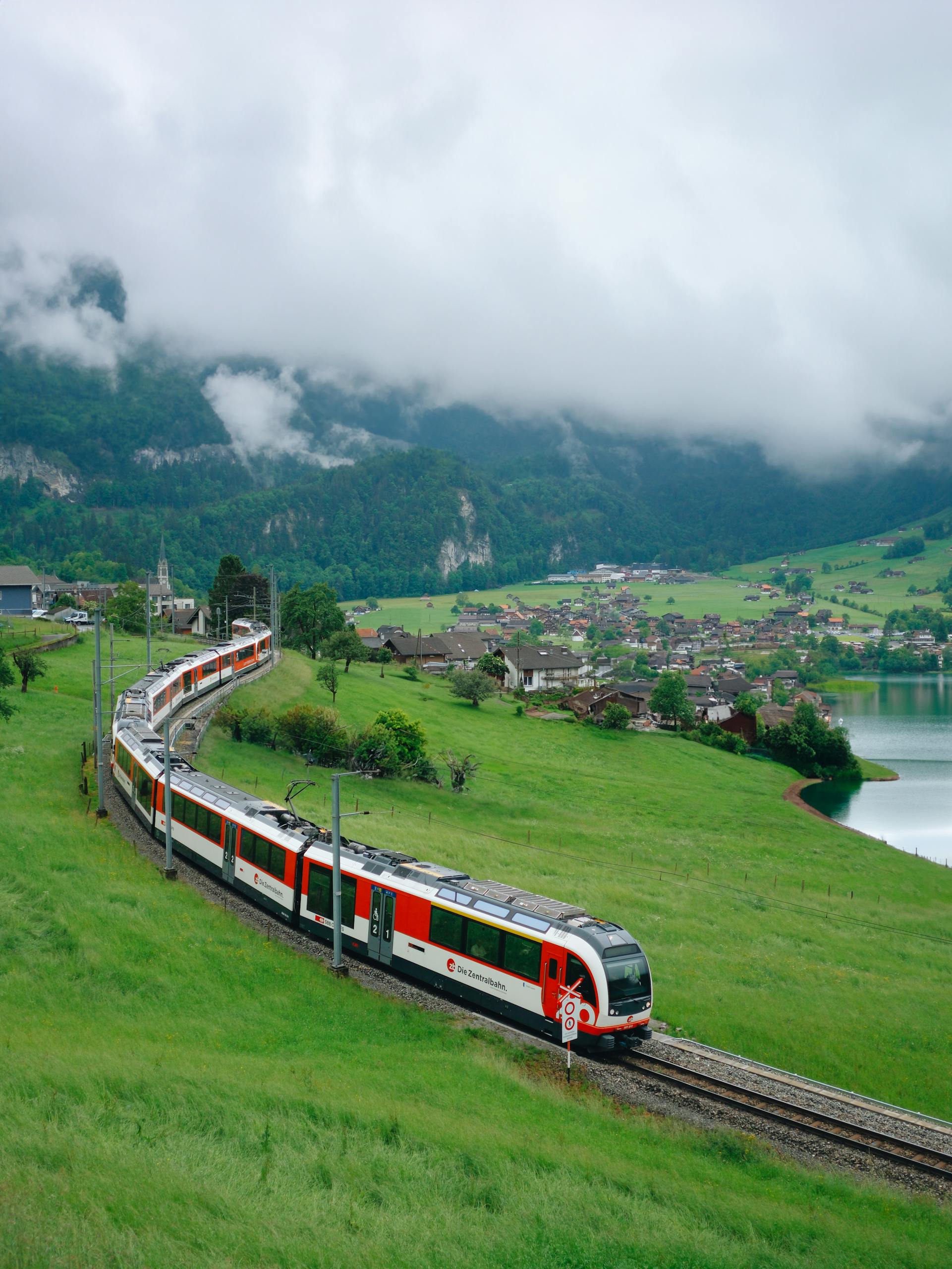 Picturesque train journey through Lungern's lush landscape with lakes and mountains.