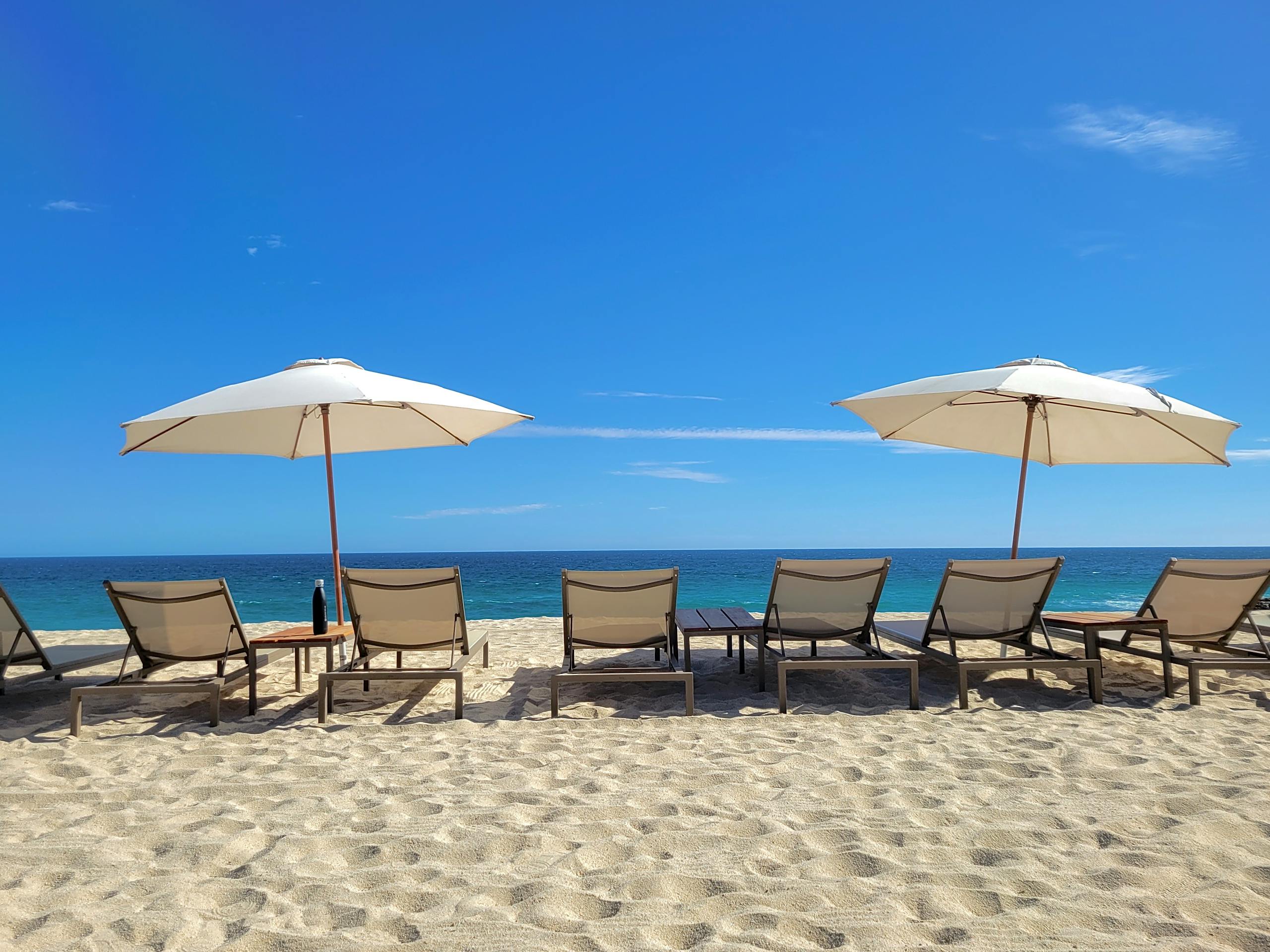 Pristine beach setting with umbrellas and loungers at Cabo San Lucas, Mexico