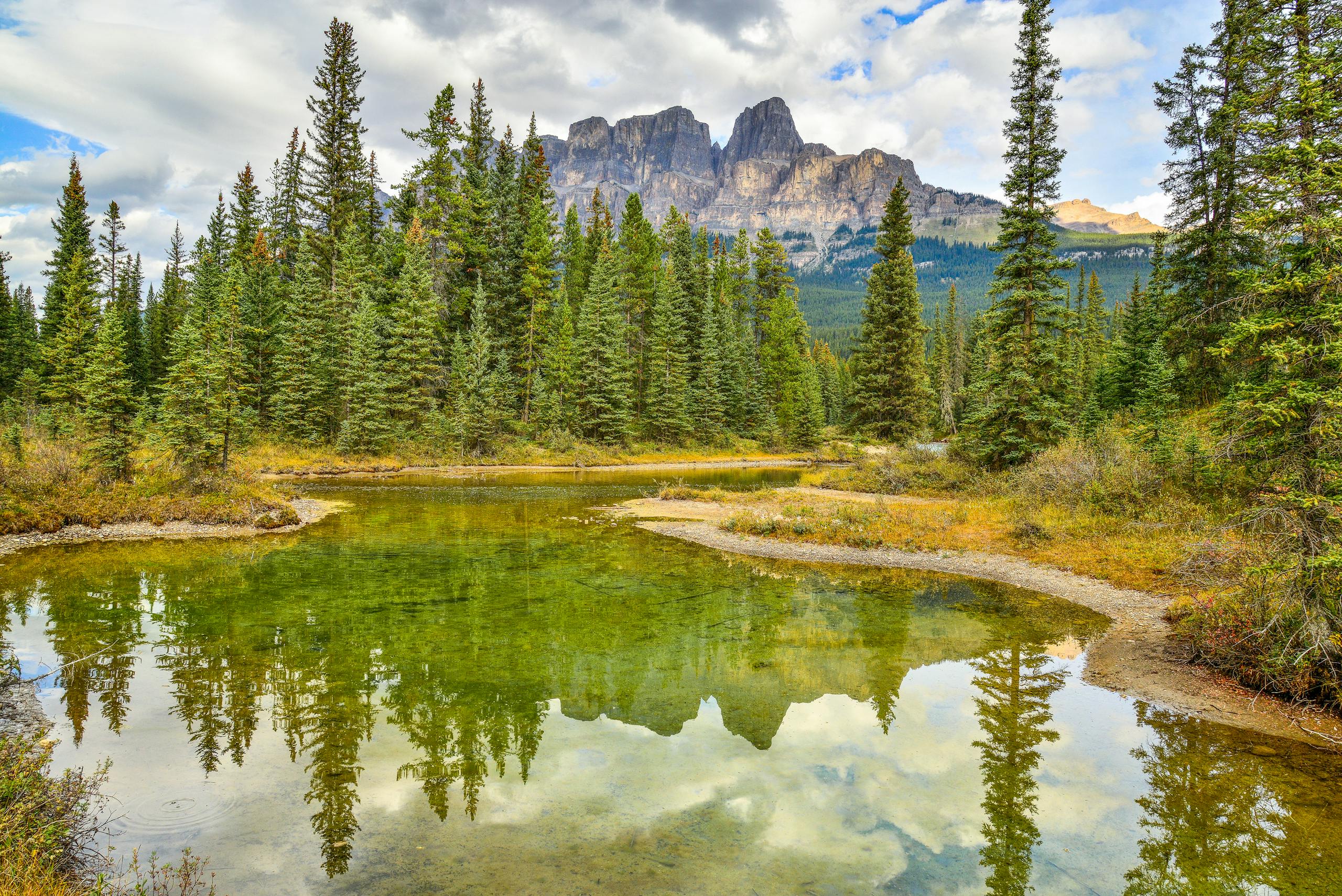 Scenic view of Castle Mountain reflecting in a tranquil lake in Banff National Park, Alberta, Canada.