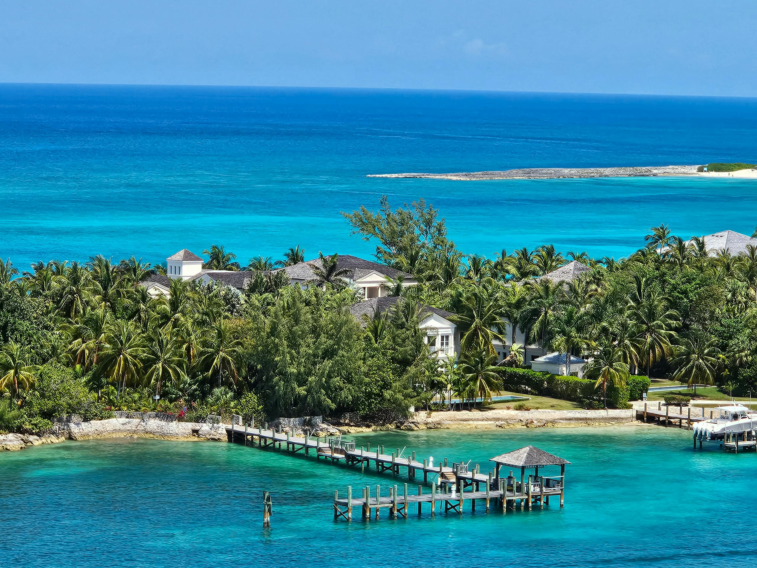 Stunning ocean and villa view in Nassau, Bahamas, featuring vibrant turquoise waters and lush palm trees.